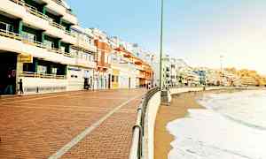 En strandpromenade med fargerike bygninger langs kysten. (AI-generert tekst)