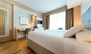 Et hotellrom med en seng, skrivebord og vindu. (AI-generert tekst)