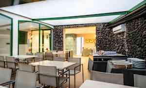 Spiseområde med bord og stoler samt en buffetoppsett ved siden av en steinvegg. (AI-generert tekst)