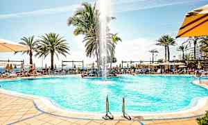 Bassengområde med solsenger, parasoller og palmer. (AI-generert tekst)