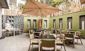 Innergård med bord og stoler samt en stor parasoll. (AI-generert tekst)