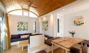 Et interiør med trebord, sofa og veggdekorasjoner med plantemotiv. (AI-generert tekst)