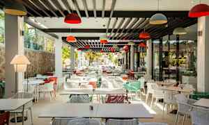 En moderne restaurant med mange fargerike stoler og bord. (AI-generert tekst)