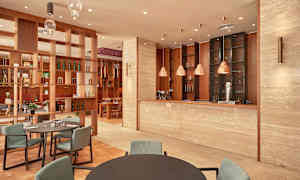 Interiør av en restaurant med moderne innredning, inkludert bord, stoler og en bardisk. (AI-generert tekst)