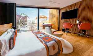 Moderne hotellrom med dobbeltseng, skrivebord, sittemøbler og utgang til en terrasse med utemøbler og boblebad. (AI-generert tekst)