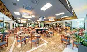 Stort restaurantområde med mange bord og stoler. (AI-generert tekst)