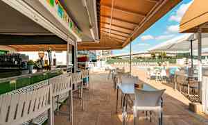 Uteservering med bord og stoler ved et basseng. (AI-generert tekst)