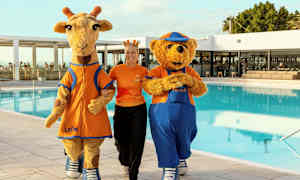 To maskoter, en giraff og en bjørn, ved et basseng på en ferieanlegg. (AI-generert tekst)