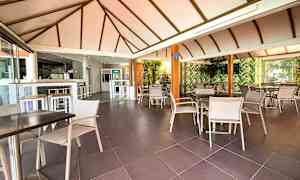 Restaurant med sittegrupper og tak med bjelker. (AI-generert tekst)