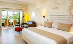 Et hotellrom med en dobbeltseng, en sittegruppe og en balkong. (AI-generert tekst)