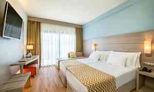 Dobbeltrom med moderne innredning, lyse farger og en stor seng. (AI-generert tekst)