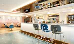 Moderne hotellbar med sitteplasser og hyller fulle av flasker. (AI-generert tekst)