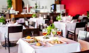 Dekket bord på restaurant med mat og drikke. (AI-generert tekst)