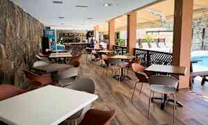 En romslig utendørsservering med bord og stoler ved et basseng. (AI-generert tekst)