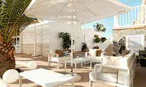 Utendørs loungemøbler med sofaer, parasoll og et bord på en terrasse. (AI-generert tekst)