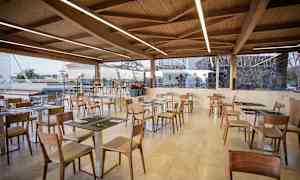 En restaurant med treinteriør og glassvinduer. (AI-generert tekst)