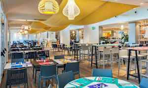 Interiør av en restaurant med ferdig bordsetting og stoler. (AI-generert tekst)