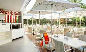 Utendørs servering med bord og stoler under parasoller. (AI-generert tekst)