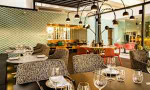 Moderne restaurant med dekkede bord, stoler og dekorativ belysning. (AI-generert tekst)