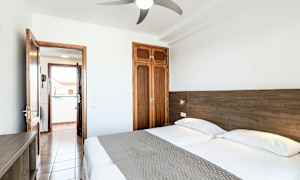 Dobbeltrom med to senger, dør til balkong og garderobe. (AI-generert tekst)