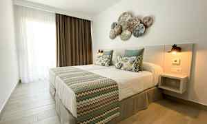 Et soverom med en dobbeltseng, pynteputer og et dekorert hodegjerde. (AI-generert tekst)