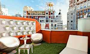 Takterrasse med sittemøbler og utsikt over byens arkitektur. (AI-generert tekst)