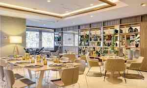 Et moderne innredet spisested med bord, stoler og dekorative detaljer. (AI-generert tekst)