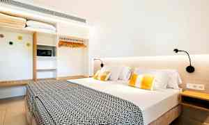 Hotellrom med en dobbeltseng, leselamper og en garderobe. (AI-generert tekst)