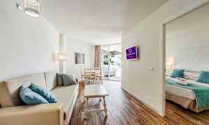 Bilde av et hotellrom med stue, sofa, spisebord og tilstøtende soverom. (AI-generert tekst)