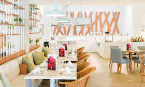 Åpent restaurantlokale med bord, stoler og dekorative trepaneler. (AI-generert tekst)