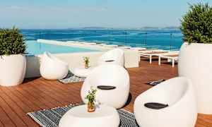 Loungeområde ved et basseng med moderne møbler og utsikt over havet. (AI-generert tekst)