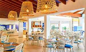 Lys og luftig restaurant med elegant møblement og store kurvlamper. (AI-generert tekst)