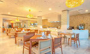 En restaurant med bord og stoler, lysekroner i taket og en serveringsdisk. (AI-generert tekst)