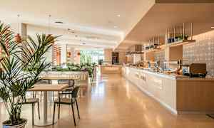 Lyst og moderne spiseområde med bord, stoler og buffébord. (AI-generert tekst)