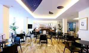 Et moderne interiørområde med svarte bord og stoler, dekorative planter og en lys atmosfære. (AI-generert tekst)