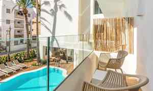 Privat balkong med utsikt over et basseng og solsenger. (AI-generert tekst)