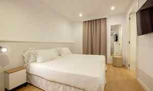 Et hotellrom med to senger dekket med hvitt sengetøy. (AI-generert tekst)