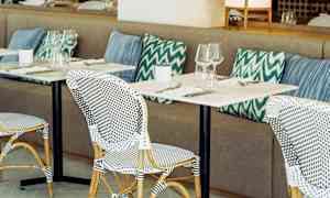 Restaurant med bordoppsett og puter. (AI-generert tekst)