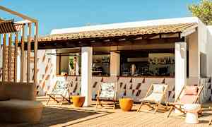 En utendørs bar med stoler og bord på en treterrasse. (AI-generert tekst)