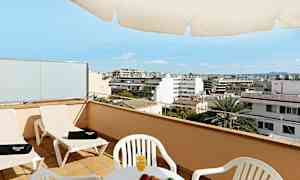 En terrasse med stoler, et bord med frukt og juice og utsikt over en by. (AI-generert tekst)