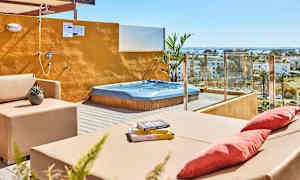 Terrasse med boblebad, sittemøbler og åpen dusj med utsikt over omgivelsene. (AI-generert tekst)