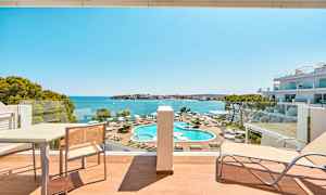 Hotellromvy mot bassengområde og hav. (AI-generert tekst)