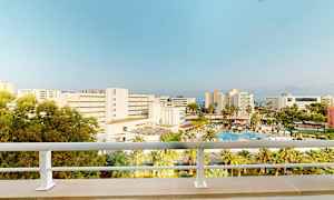 Hotell og bassengområde sett fra en balkong. (AI-generert tekst)