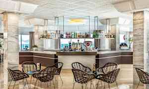 Hotellbar med stoler og bord i forgrunnen. (AI-generert tekst)