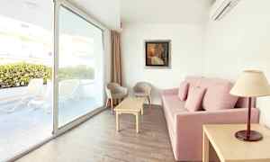 Sofa med rosa trekk, stuebord, to stoler og vindu med utsikt mot terrassen. (AI-generert tekst)