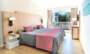 Et hotellrom med to enkeltsenger, en balkong og moderne innredning. (AI-generert tekst)