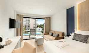 Et hotellrom med en dobbeltseng, sofa og balkong som vender mot et basseng. (AI-generert tekst)