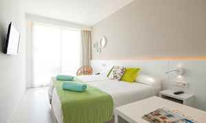 Et moderne hotellrom med to enkeltsenger og grønne detaljer. (AI-generert tekst)