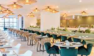 Restaurant med sitteplasser, bord og belysning. (AI-generert tekst)