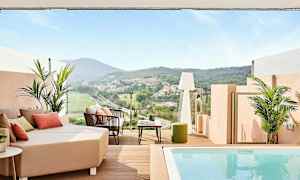 En terrasse med utsikt over en grønn dal og hus i det fjerne, med sittemøbler og et lite basseng. (AI-generert tekst)